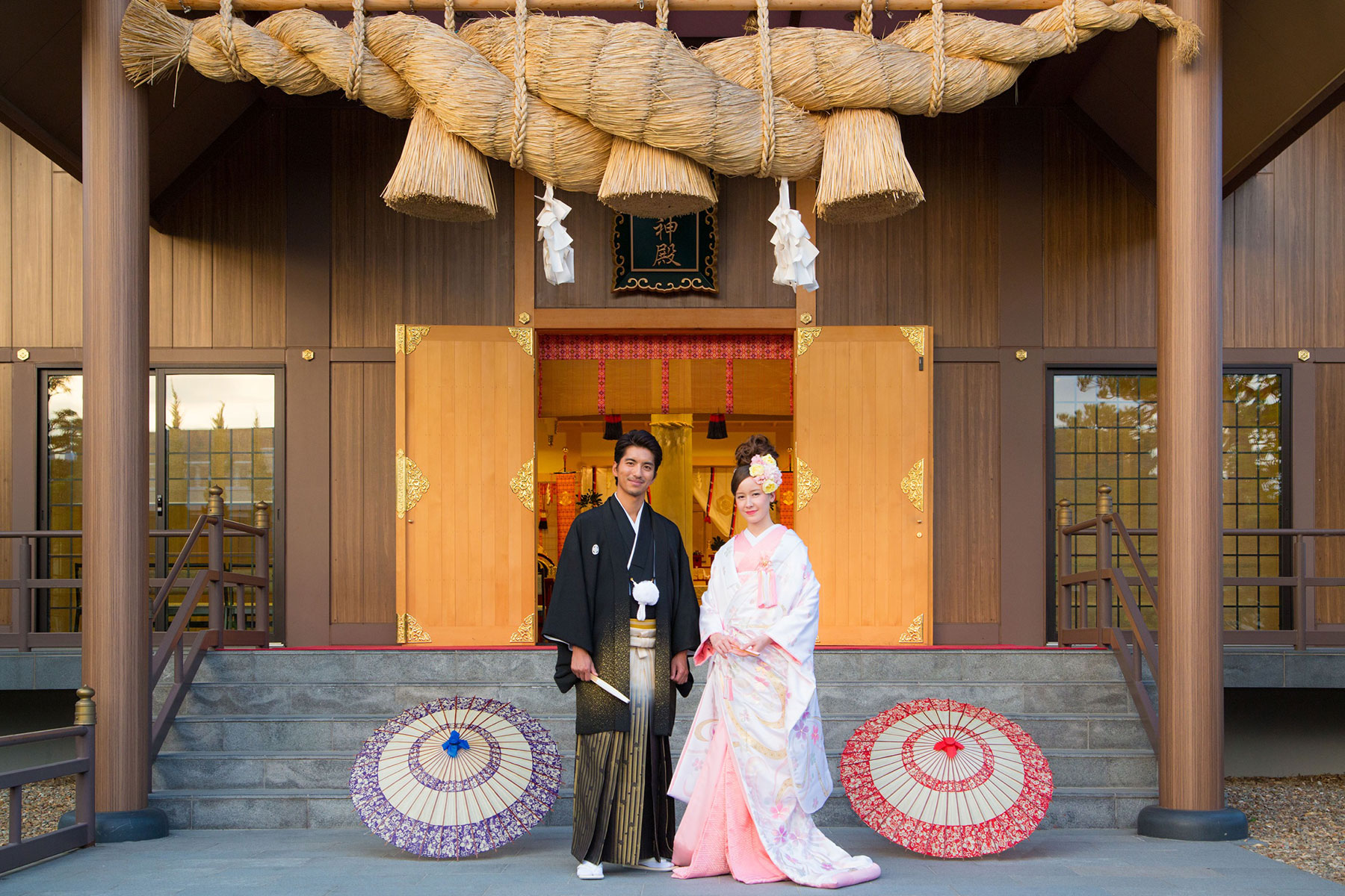 神殿の前に立つ和装の新郎新婦