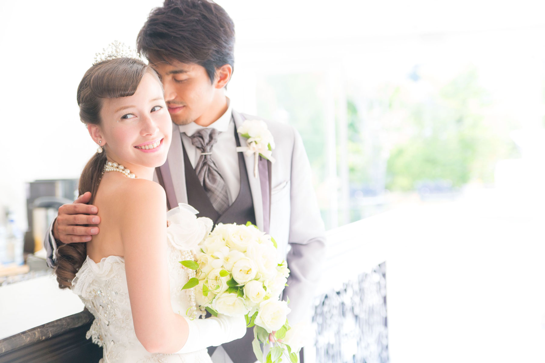 明るい室内で寄り添う新郎新婦