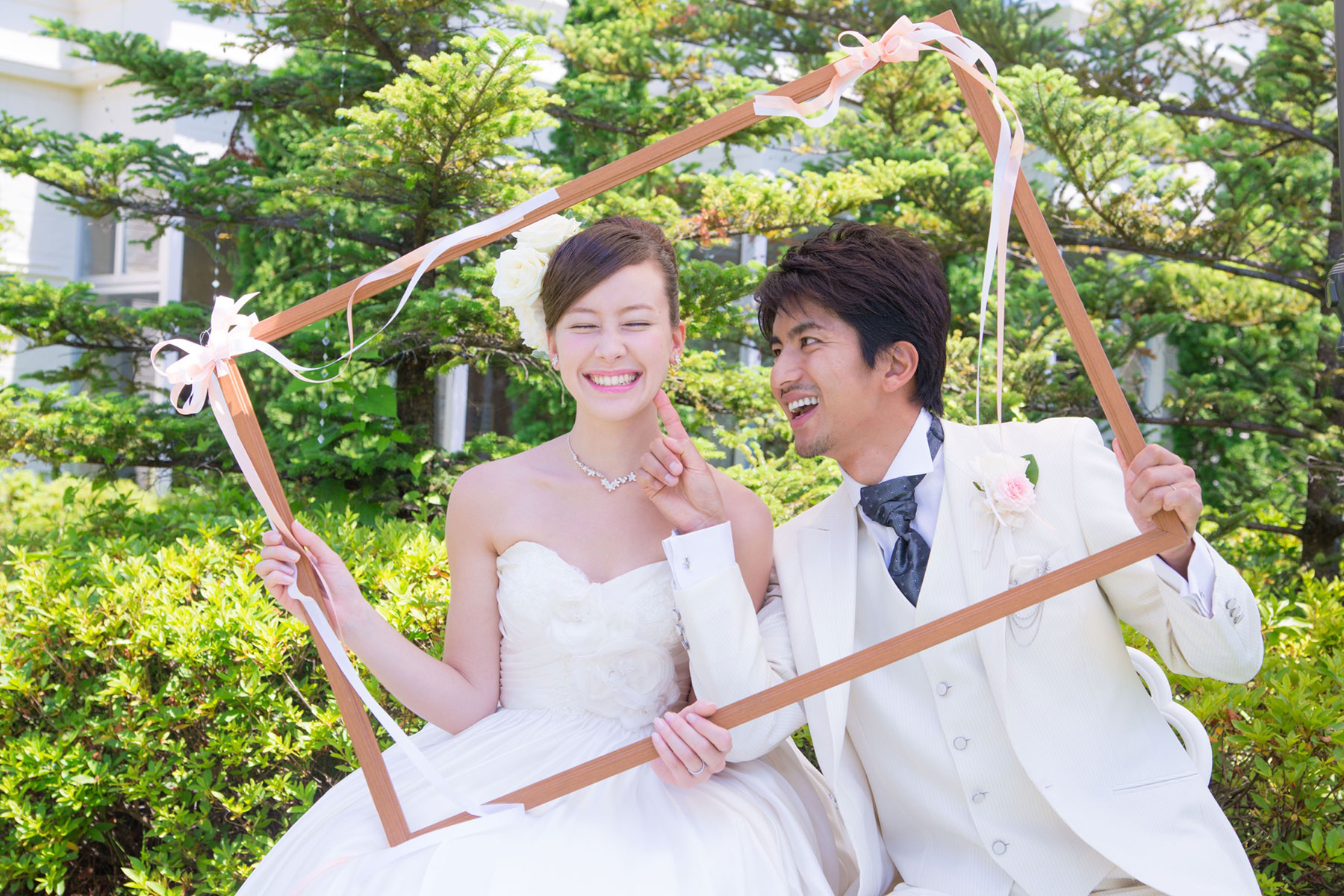 フレームを持って笑う新郎新婦
