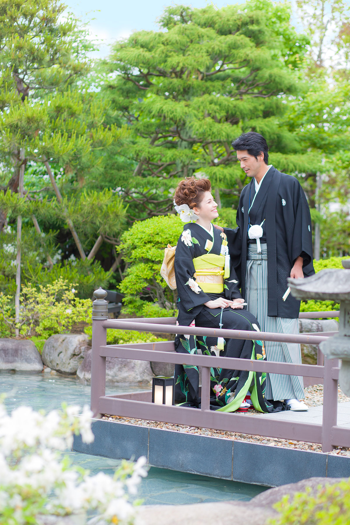 庭園で見つめ合う和装の新郎新婦