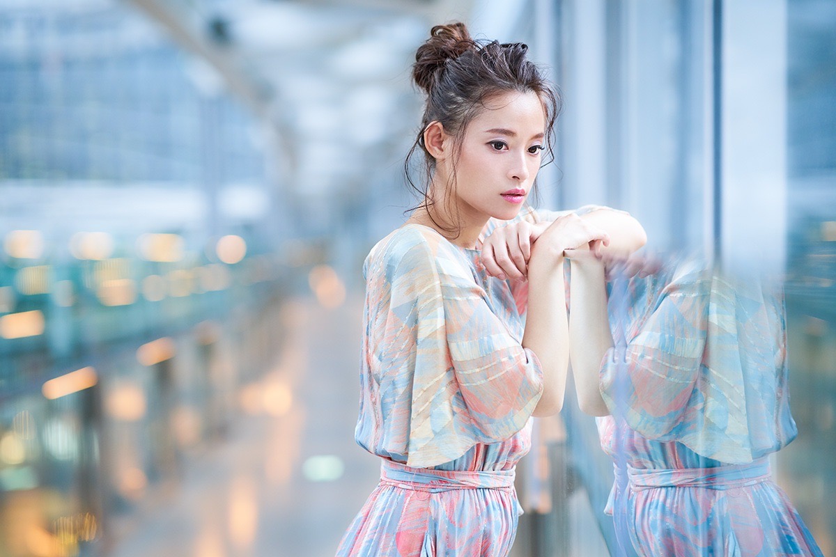ガラスに腕を寄せた女性のポートレート