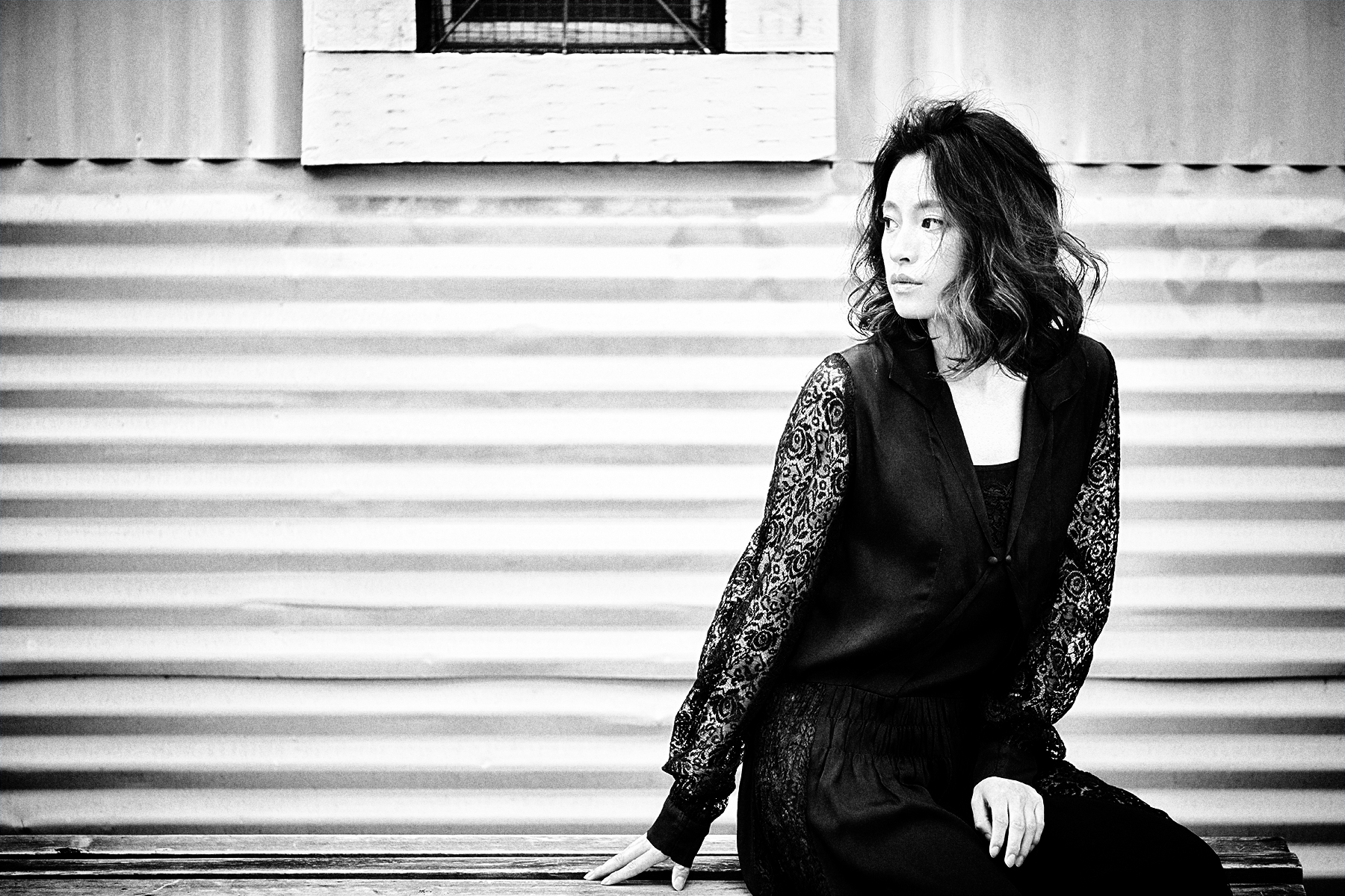 黒いレースの衣装をまとった女性のモノクロポートレート